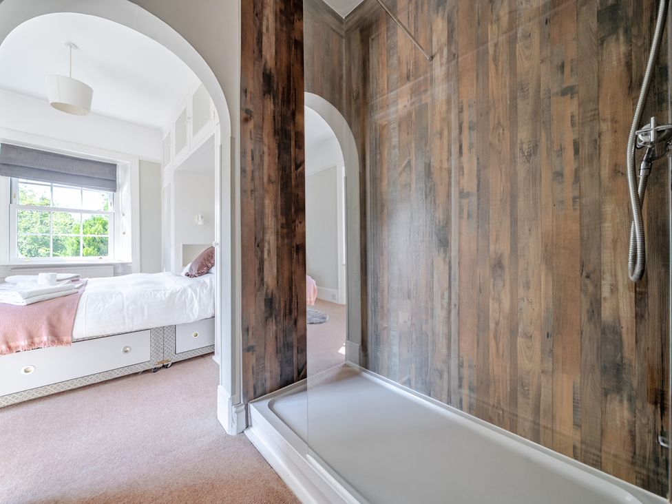 A bedroom with a bed and shower area at Milton Manor in Milton On Stour