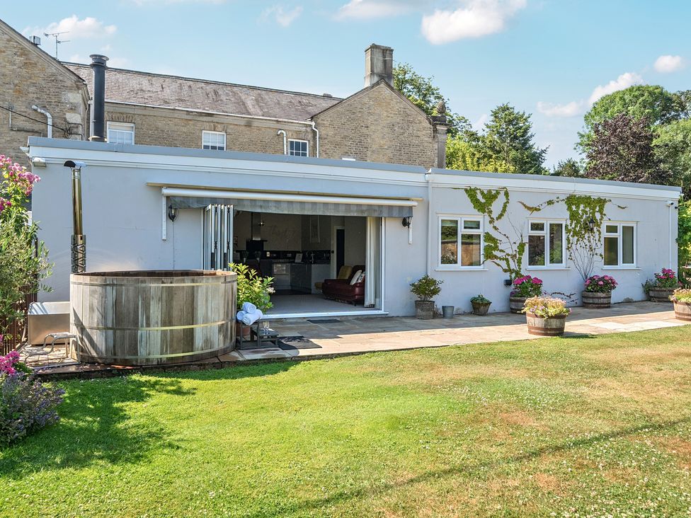 A garden with a hot tub and flowers at Milton Manor in Milton On Stour