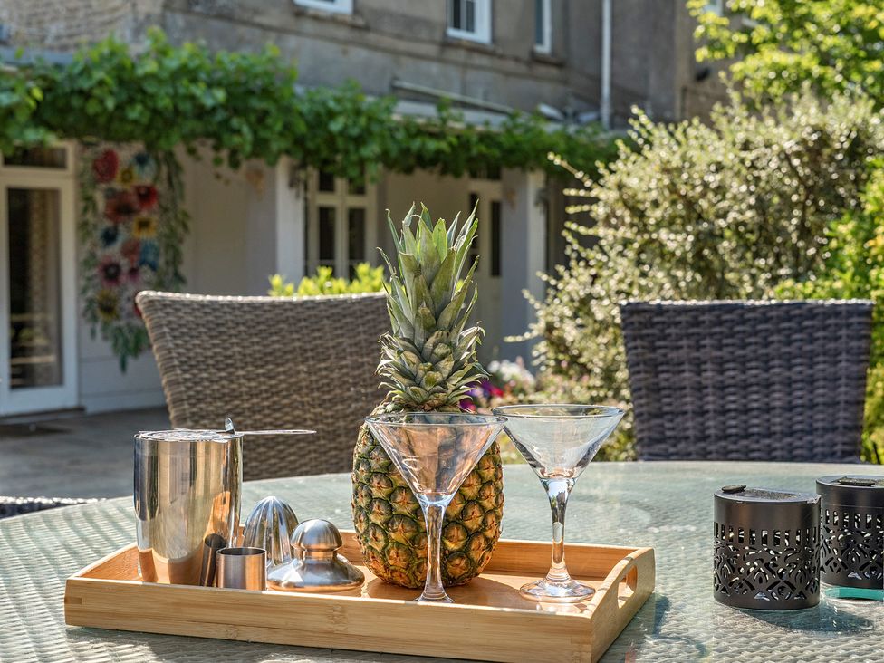 An outdoor area with a tray, pineapple and glassware at Milton Manor Milton On Stour