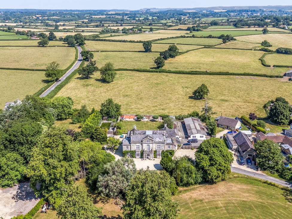 An aerial view of a house surrounded by fields at Milton Manor in Milton On Stour