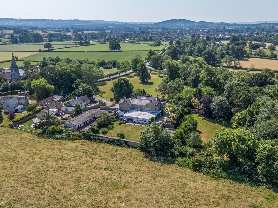 An aerial view of a village with houses and fields at Milton Manor in Milton On Stour