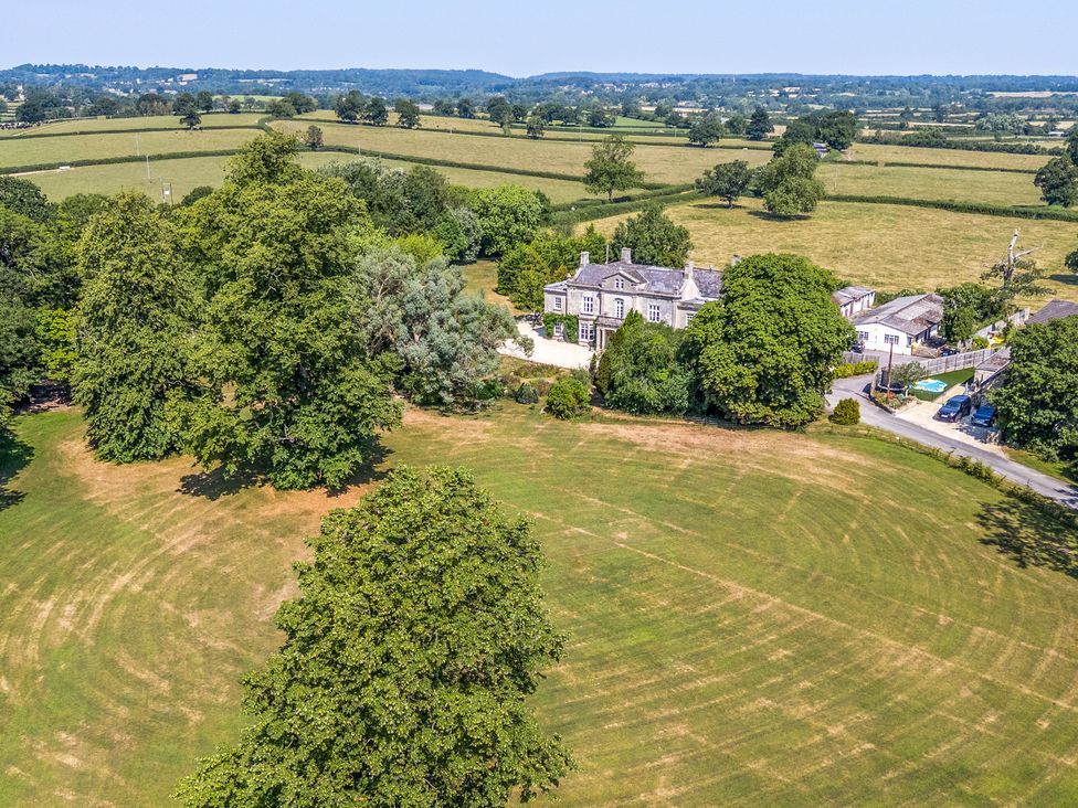 A property with trees and a large lawn at Milton Manor in Milton On Stour