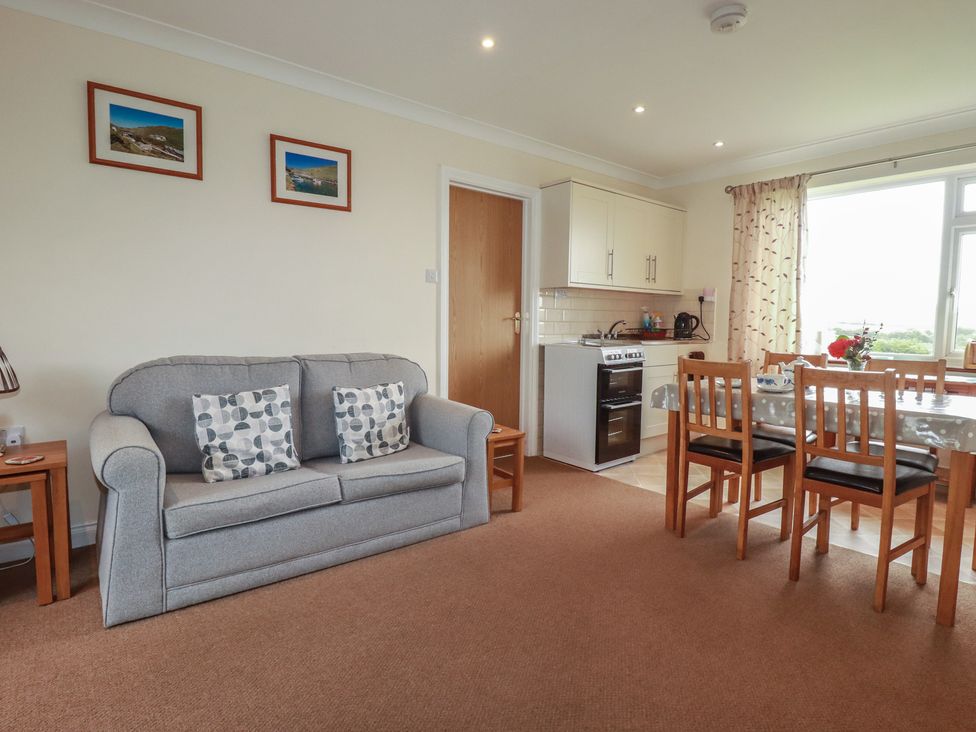 A living room with a sofa and dining area at Little Lanes in Boscastle