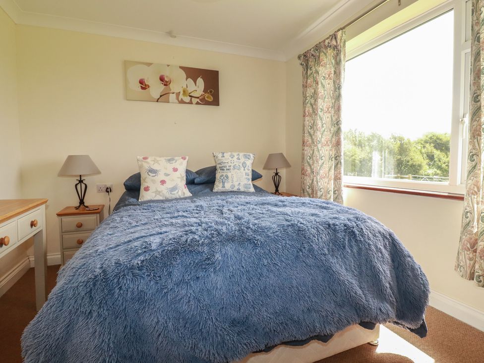 A bedroom with a bed and a window at Little Lanes in Boscastle