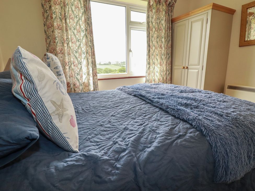 A bedroom with a bed and curtains at Little Lanes in Boscastle