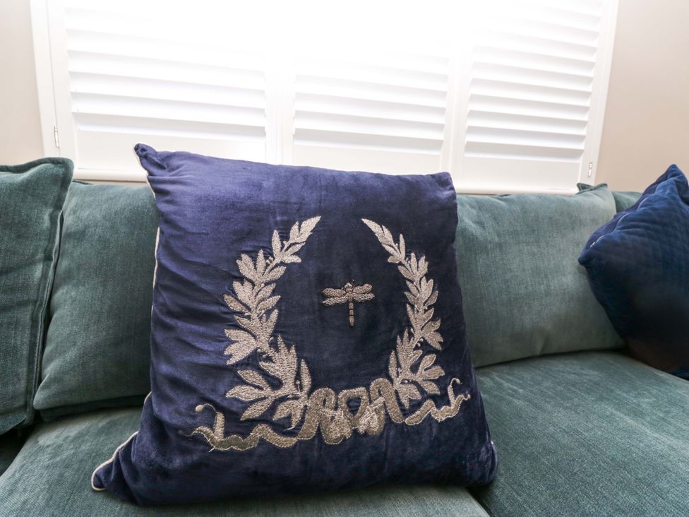 A blue cushion on a green sofa at Bishop Fell in Newby Bridge