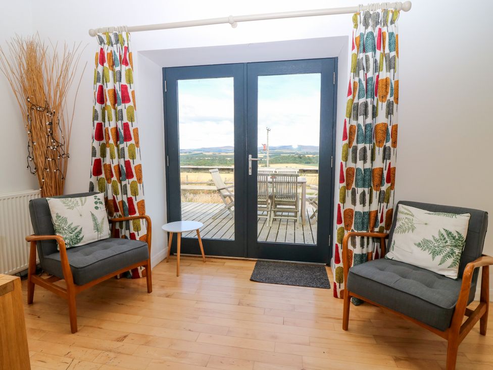 A snug with seating and double doors leading outside at Whitehouse Woodwrae Aberlemno near Forfar