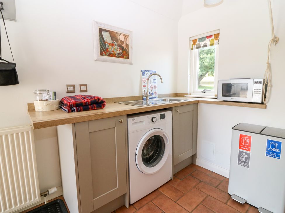 A kitchen with a washing machine and sink at Whitehouse Woodwrae, Aberlemno near Forfar