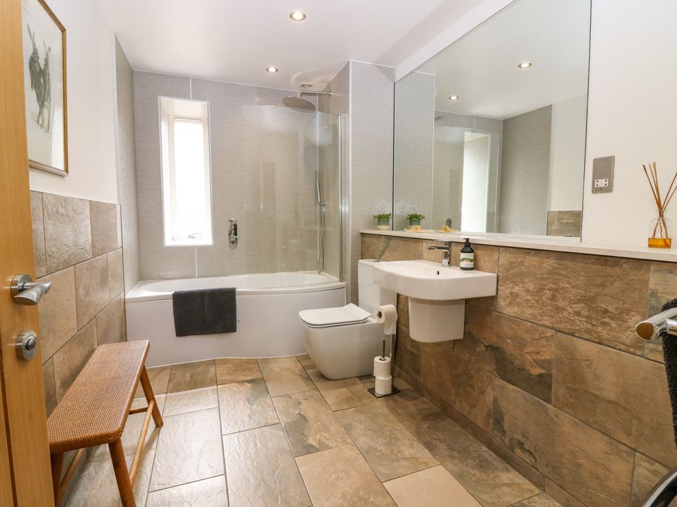 A bathroom with a bathtub, shower, toilet, and sink at Whitehouse Woodwrae Aberlemno near Forfar