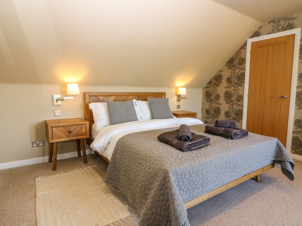A bedroom with a bed and bedside table at Whitehouse Woodwrae Aberlemno near Forfar