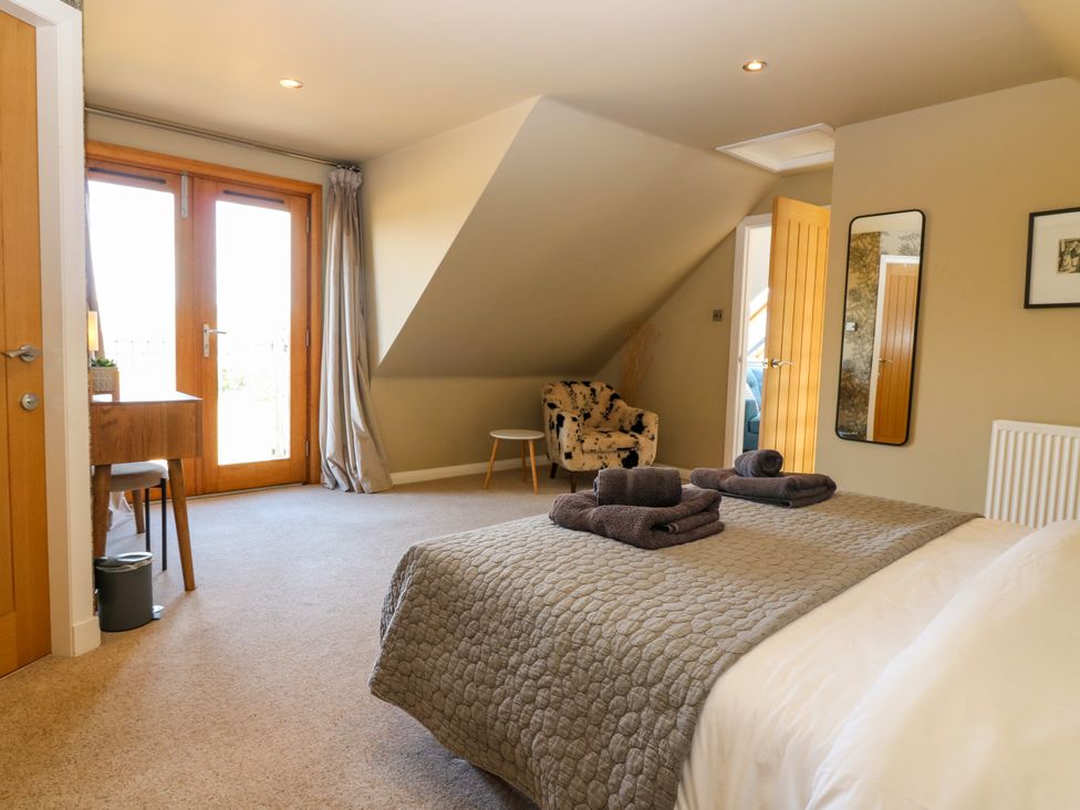 A bedroom with a bed and a table at Whitehouse Woodwrae Aberlemno near Forfar