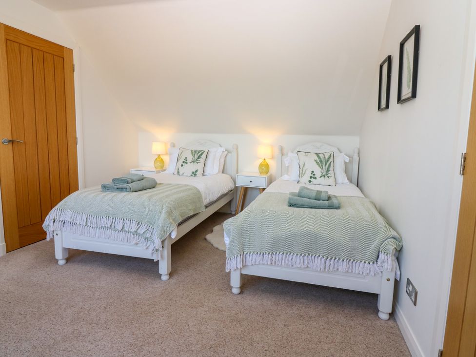 A bedroom with two beds and bedside tables at Whitehouse Woodwrae Aberlemno near Forfar