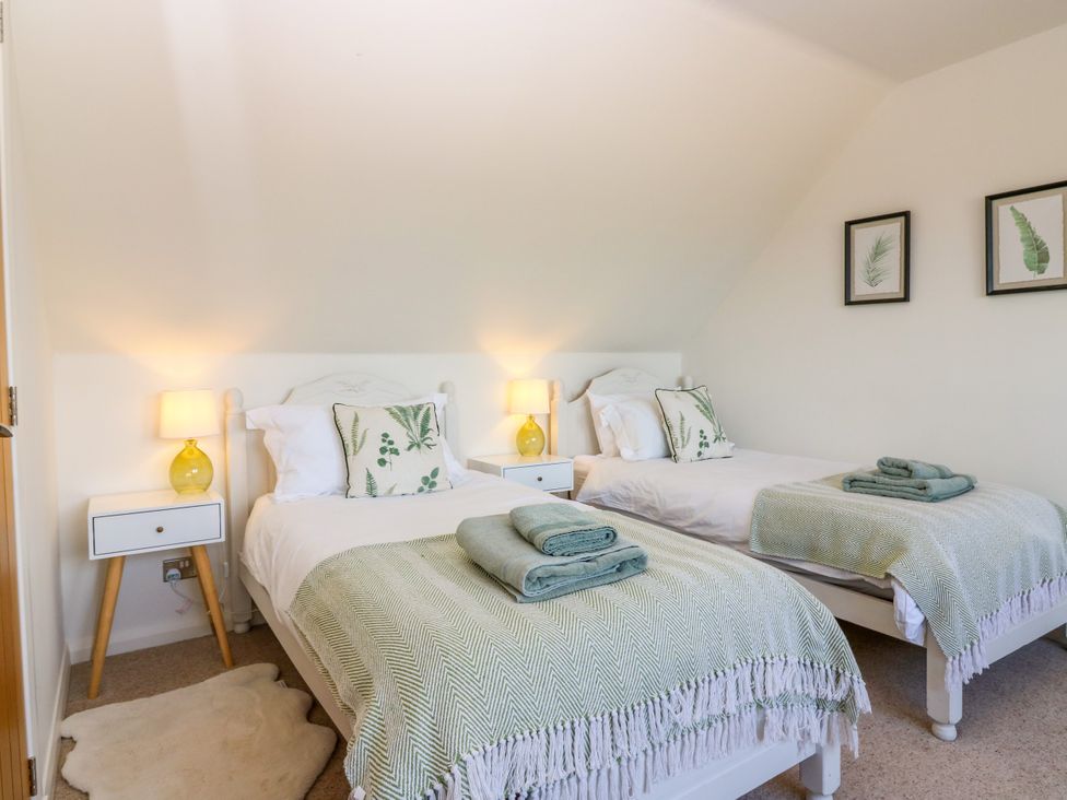 A bedroom with two beds and a bedside table at Whitehouse Woodwrae Aberlemno near Forfar