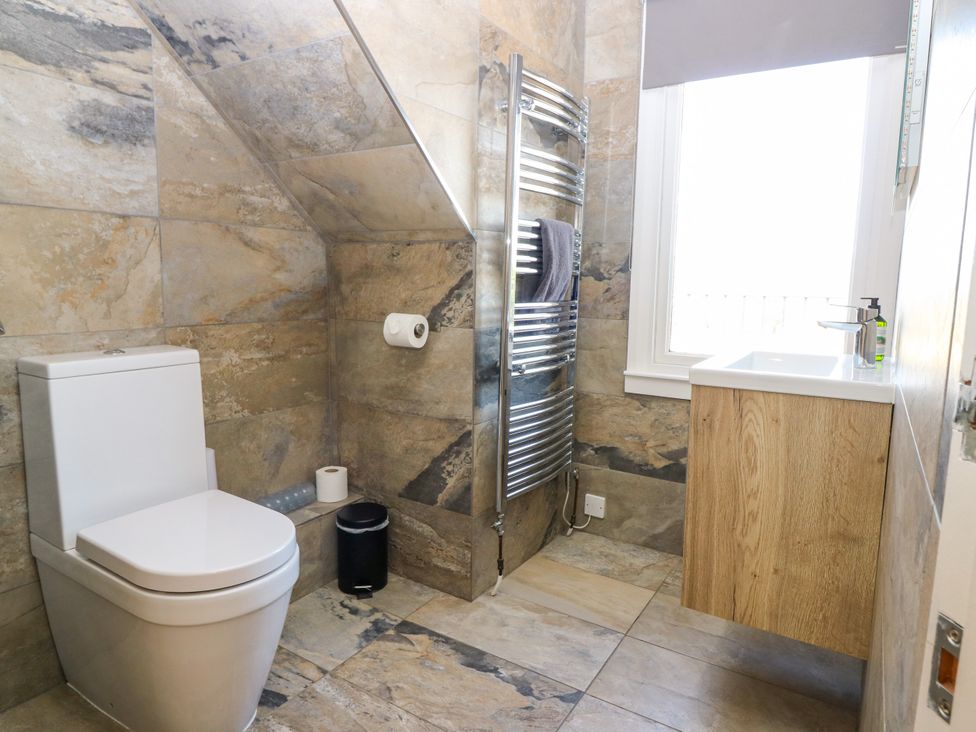A bathroom with a toilet, sink, and towel radiator at Whitehouse Woodwrae Aberlemno near Forfar