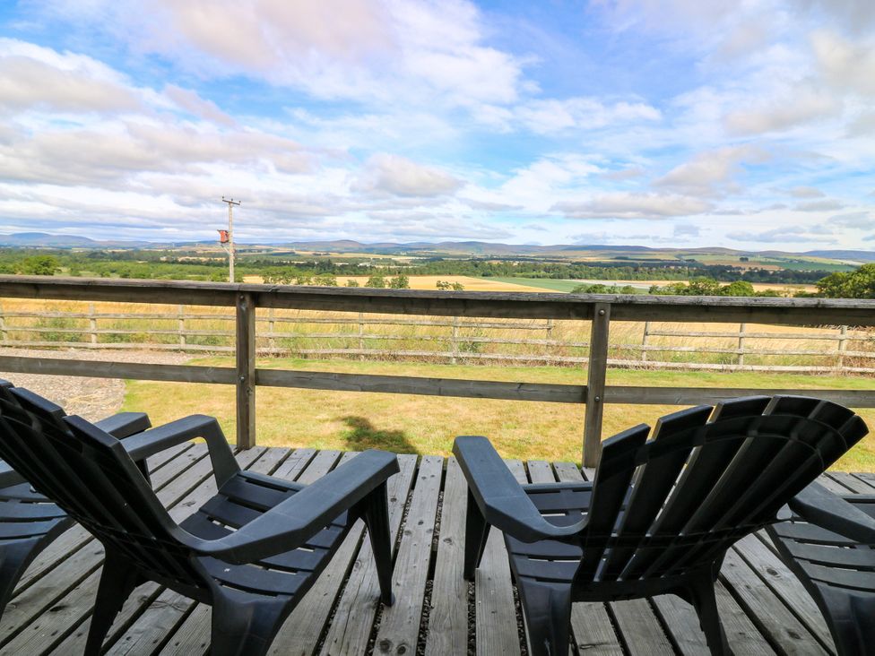 Adirondack chairs on a wooden deck overlooking a landscape at Whitehouse Woodwrae Aberlemno near Forfar