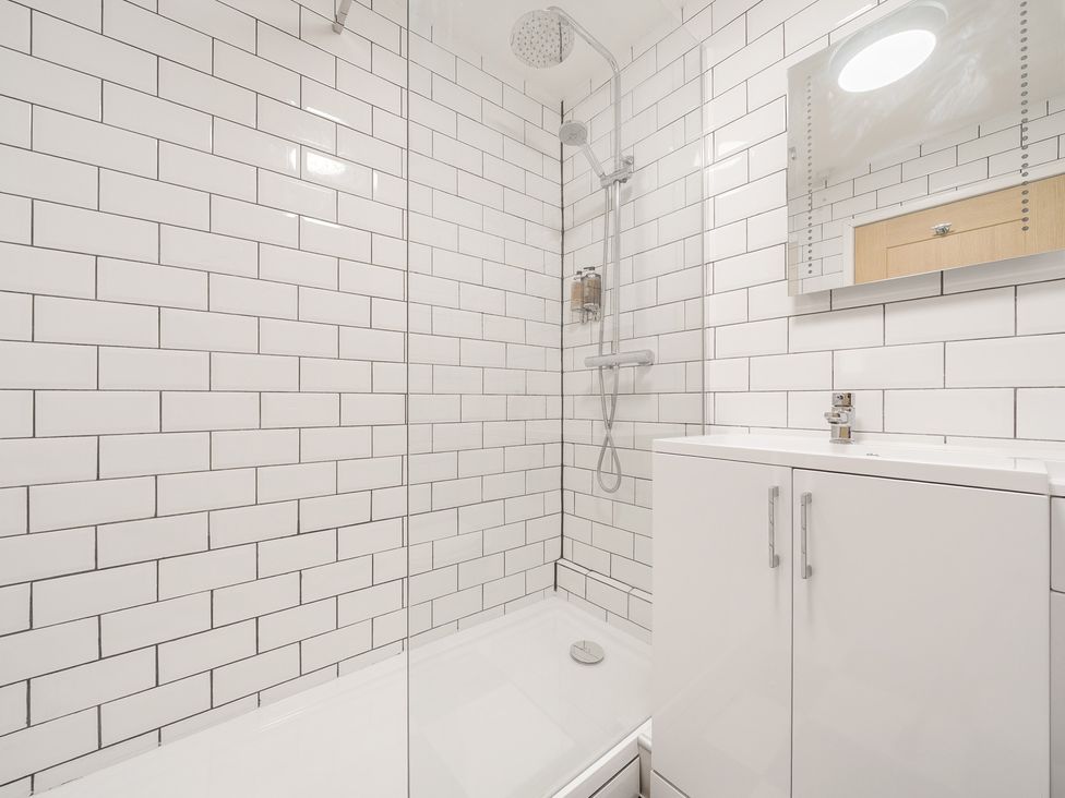 A bathroom with a shower area and white subway tiles at The Boars Head Pub in Bishops Castle