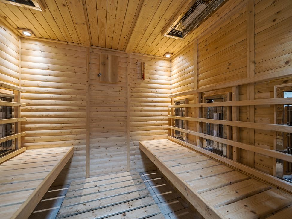 A wooden sauna room with benches on both sides and heaters along the walls at The Boars Head Pub in Bishops Castle