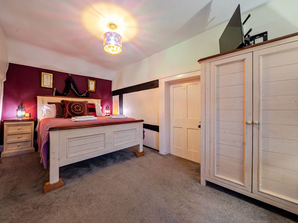 A bedroom with a bed and wardrobe at The Boars Head Pub in Bishop's Castle