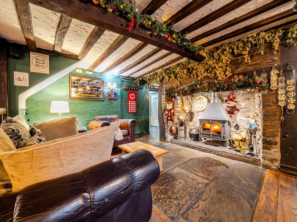 A living room with a fireplace and seating at The Boars Head Pub in Bishop's Castle