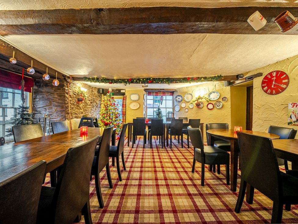 A dining room with wooden tables and chairs at The Boars Head Pub in Bishop's Castle