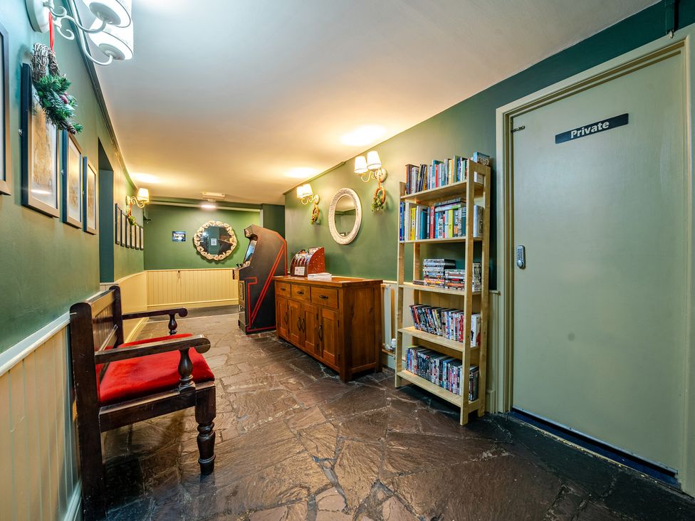 A hallway with a bench and bookshelf at The Boars Head Pub in Bishop's Castle