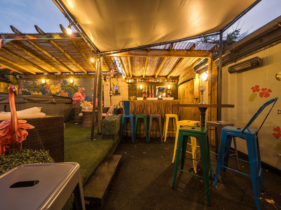 An outdoor seating area with bar stools and a table at The Boars Head Pub in Bishop's Castle