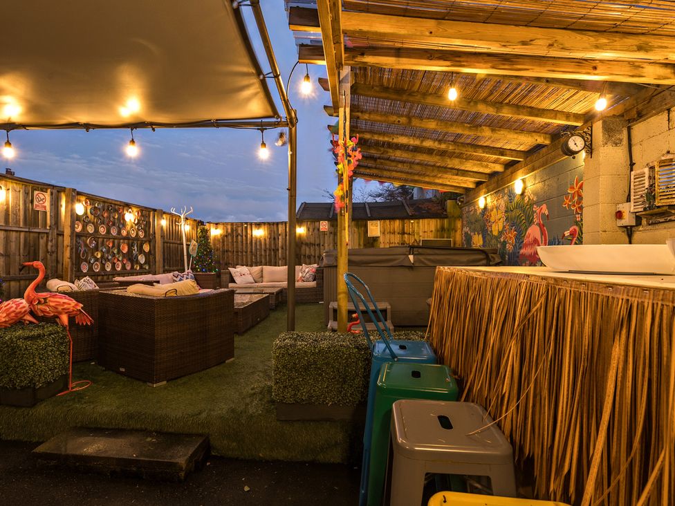 An outdoor seating area with a bar and decorations at The Boars Head Pub in Bishop's Castle