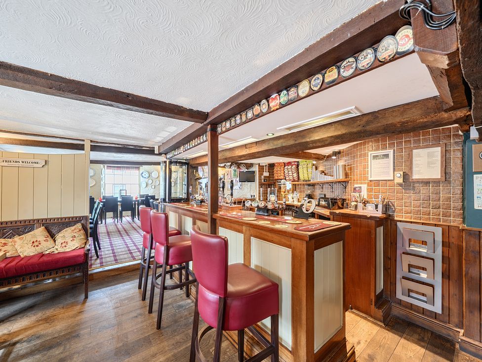A bar area with seating and tables at The Boars Head Pub in Bishop's Castle