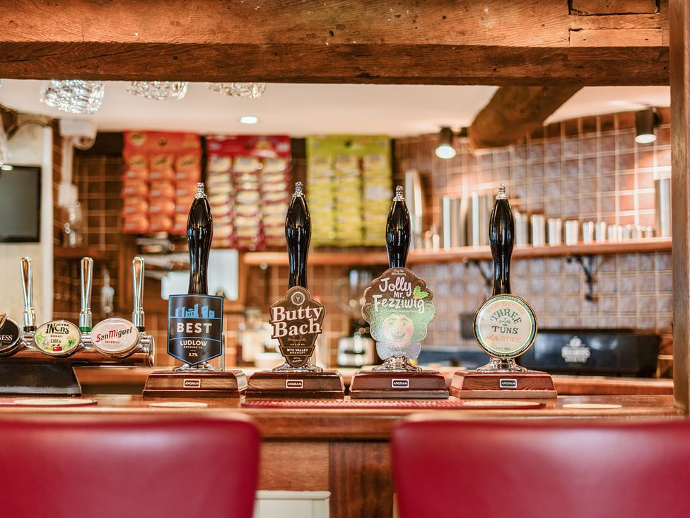 A bar area with beer taps and bottles at The Boars Head Pub in Bishop's Castle