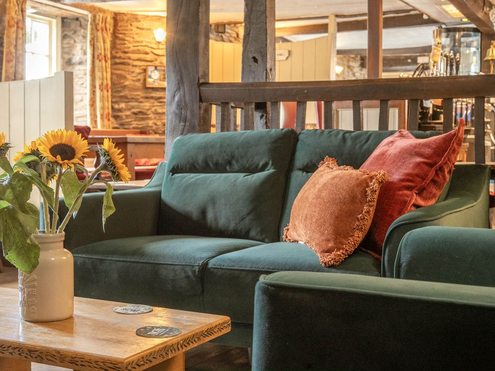A sofa with a vase of flowers and a coffee table at The Boars Head Pub in Bishop's Castle