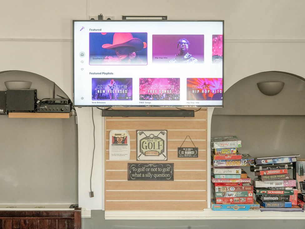 A living room with a television and board games at The Boars Head Pub in Bishop's Castle
