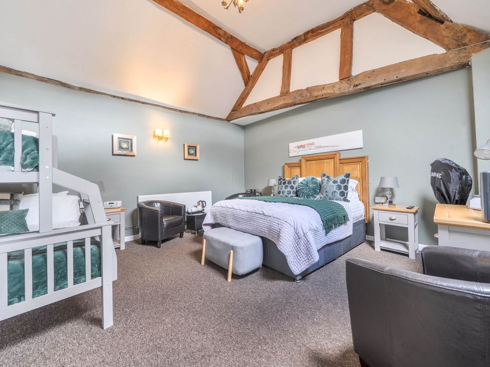 A guest room with a bunk bed and a double bed at The Boars Head Pub in Bishop's Castle