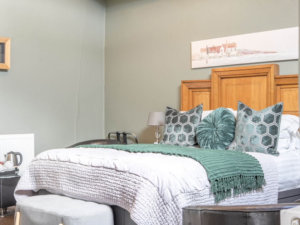 A bedroom with a bed, pillows, and a lamp at The Boars Head Pub in Bishop's Castle