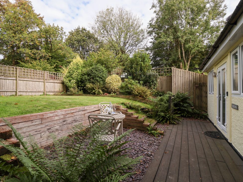 A garden with a table and chairs at Tregona Buckland Monachorum near Yelverton