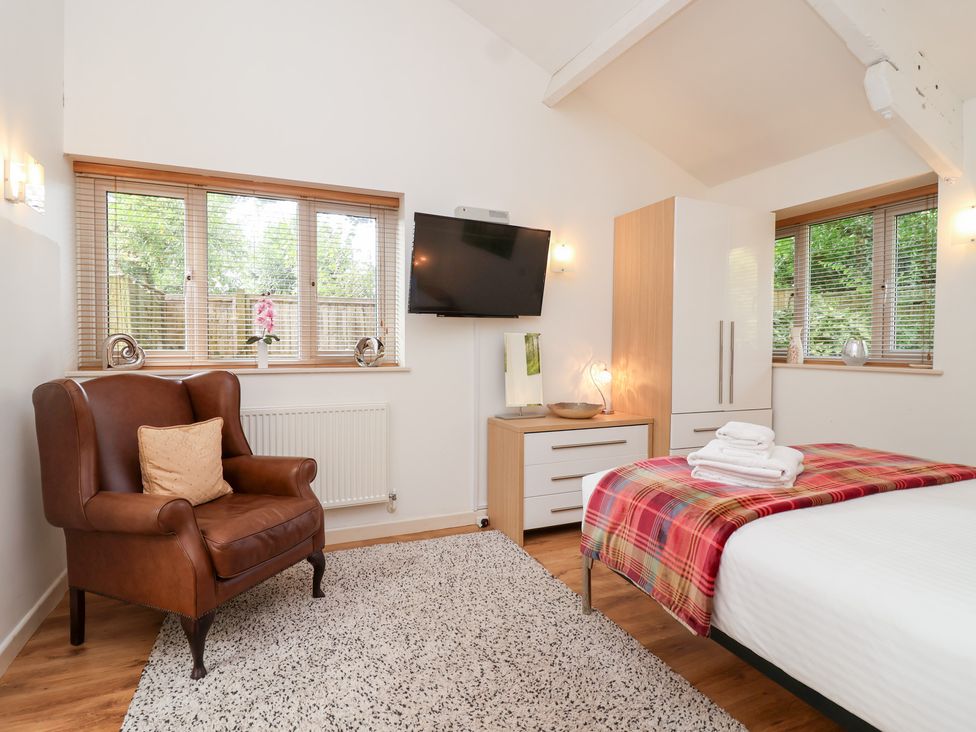 A bedroom with a bed and armchair at Tregona Buckland Monachorum near Yelverton