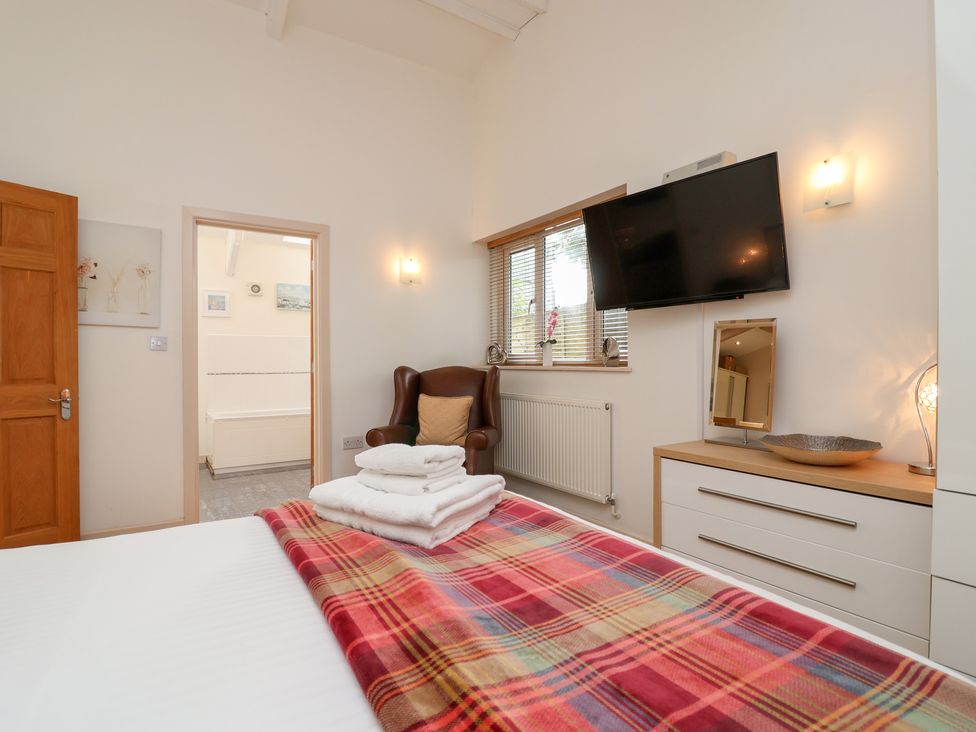 A bedroom with a bed and a television at Tregona Buckland Monachorum near Yelverton