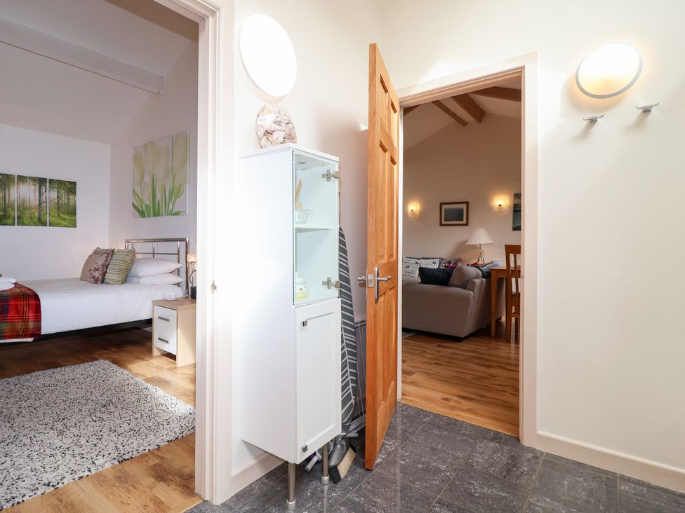 A bedroom with a bed and a doorway leading to a living area at Tregona Buckland Monachorum near Yelverton