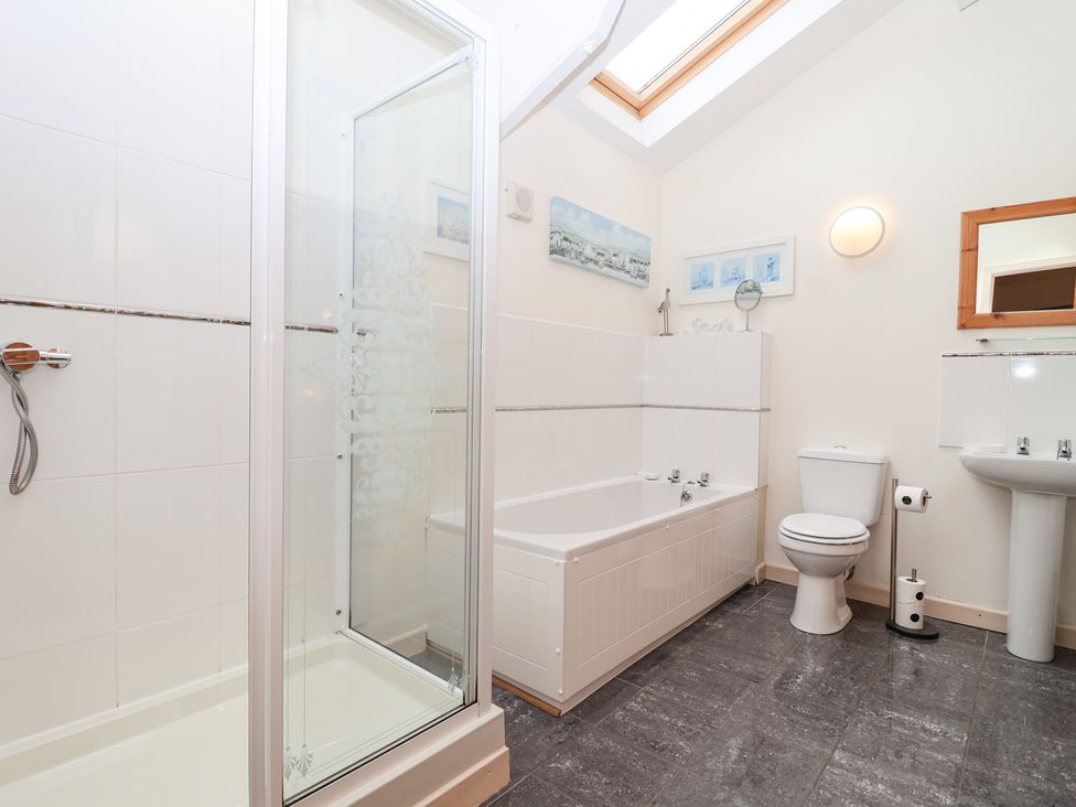 A bathroom with a shower, bathtub, toilet and sink at Tregona Buckland Monachorum near Yelverton