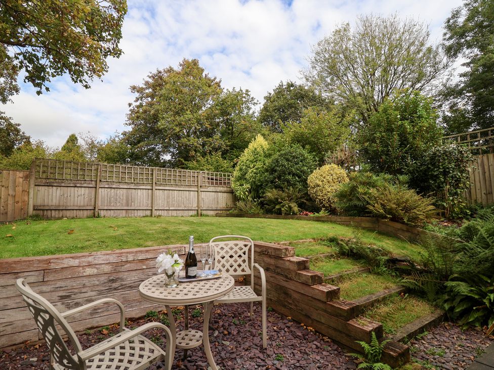 A garden with a table and chairs at Tregona Buckland Monachorum near Yelverton