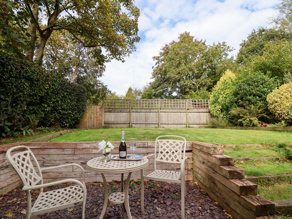 A garden with a table and chairs at Tregona Buckland Monachorum near Yelverton