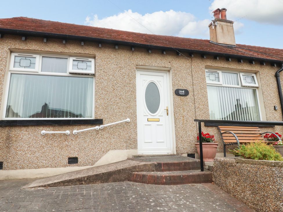 An exterior view of a house with a ramp and bench at Cosy Bee in Heysham