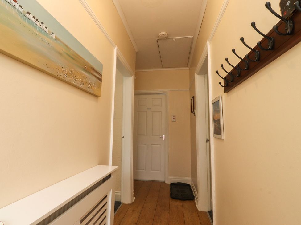 A hallway with a coat rack and a painting at Cosy Bee in Heysham