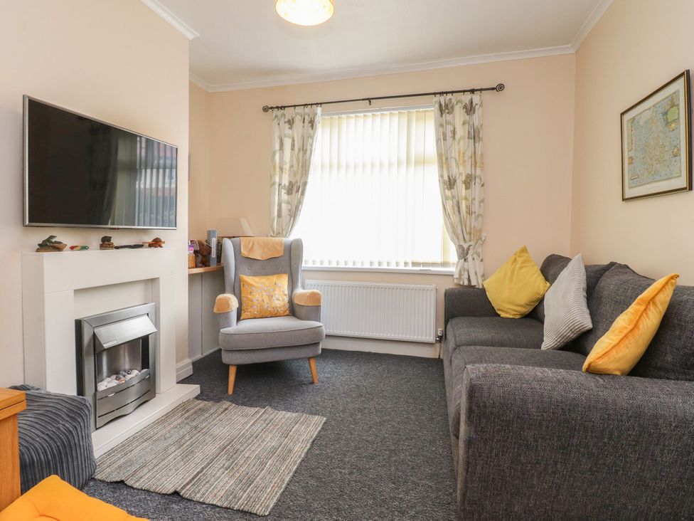 A living room with a sofa and armchair at Cosy Bee in Heysham