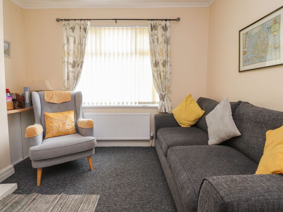 A living room with a sofa and armchair at Cosy Bee in Heysham