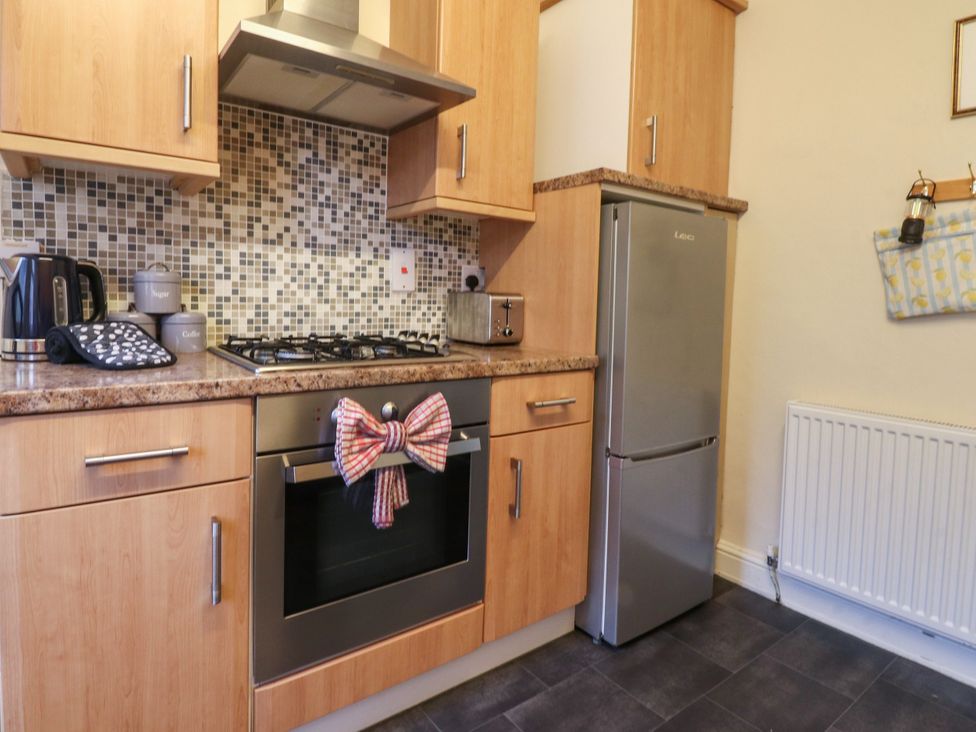 A kitchen with appliances and cabinetry at Cosy Bee in Heysham
