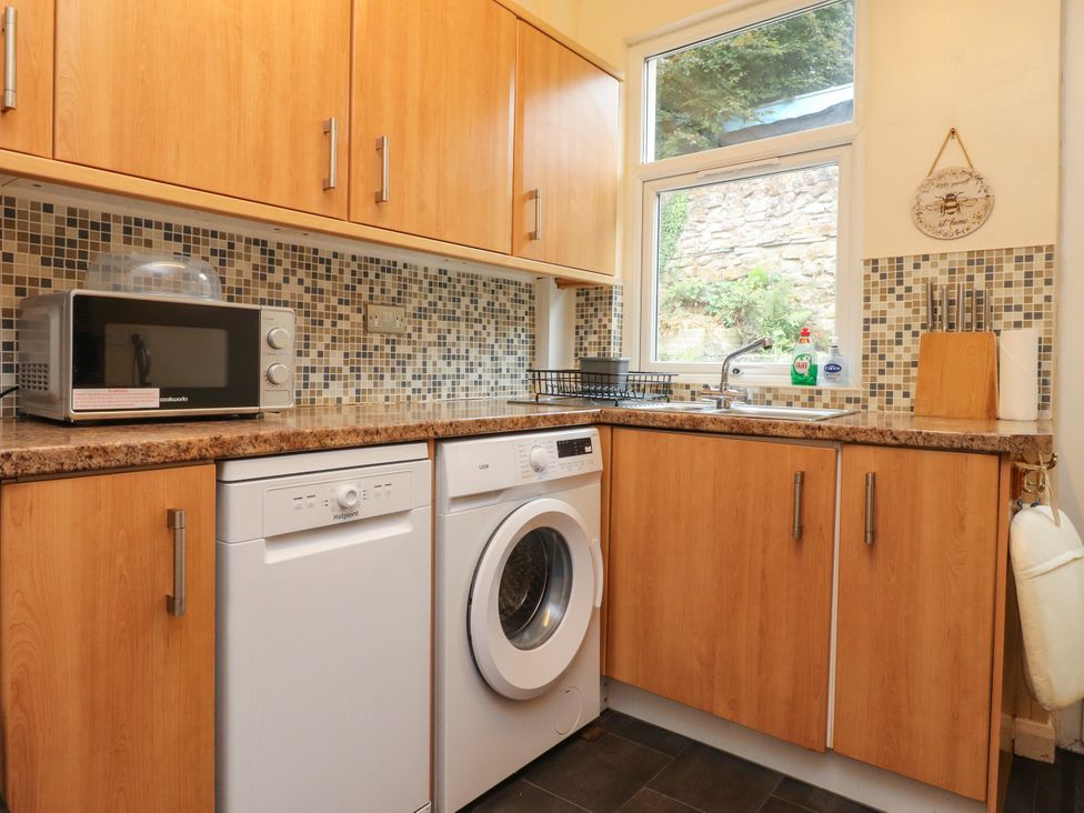 A kitchen with appliances including a dishwasher and microwave at Cosy Bee in Heysham