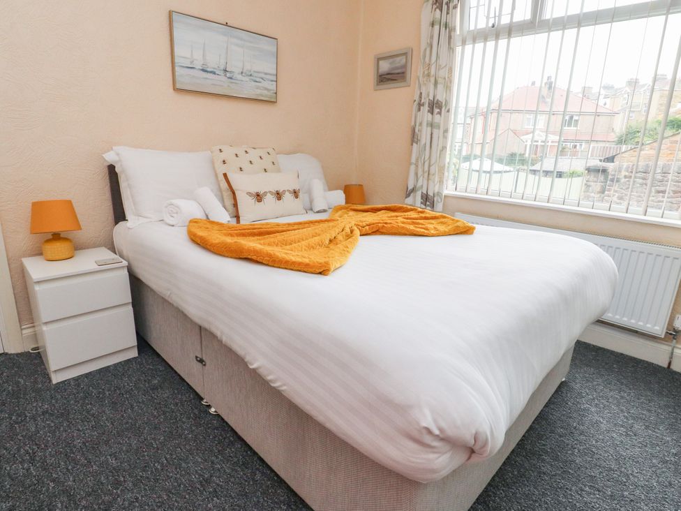 A bedroom with a bed and nightstand at Cosy Bee in Heysham