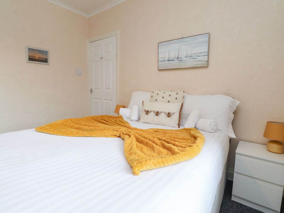 A bedroom with a bed and nightstand at Cosy Bee in Heysham