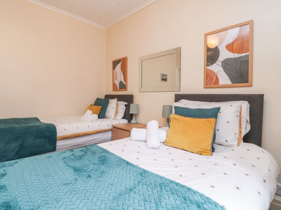 A bedroom with two beds and decorative elements at Cosy Bee in Heysham