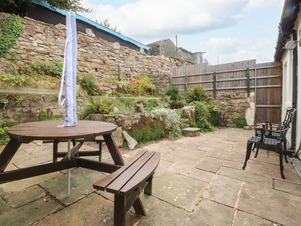 A garden with a table and chairs at Cosy Bee Heysham